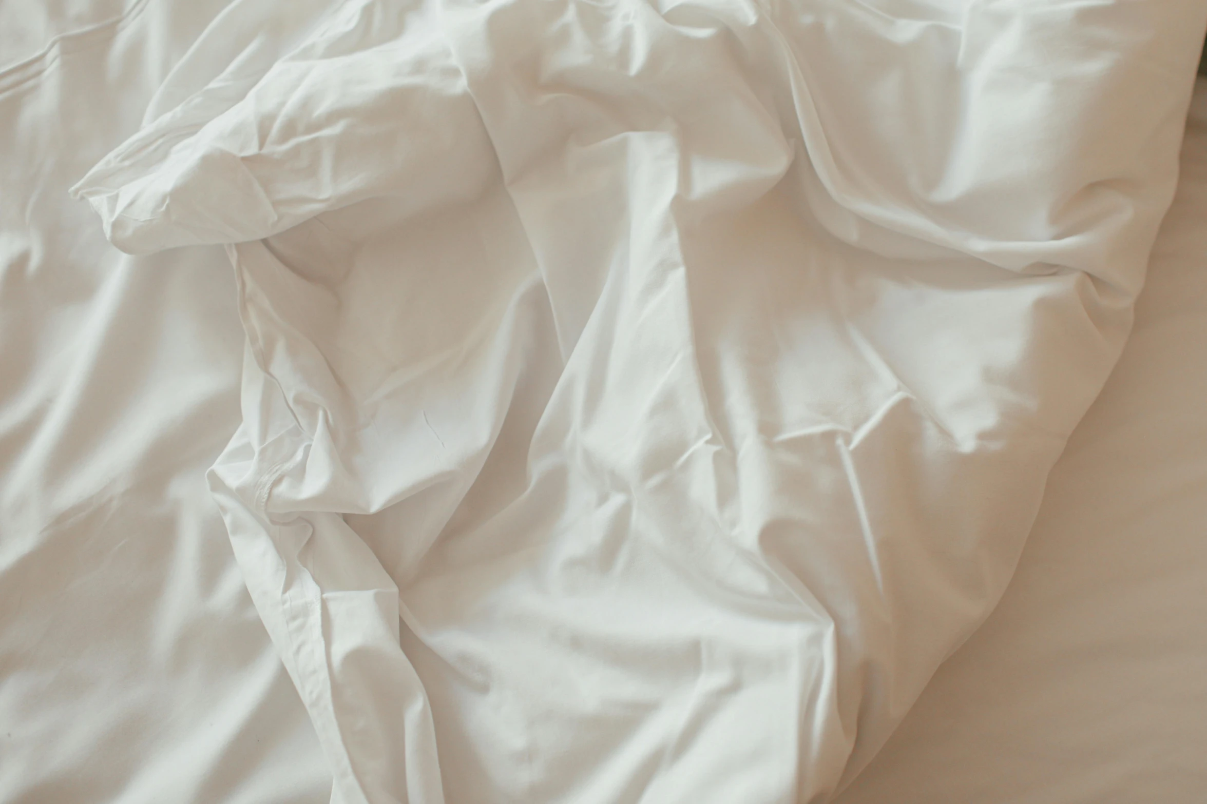 a blanket with white sheets on it is crumpled