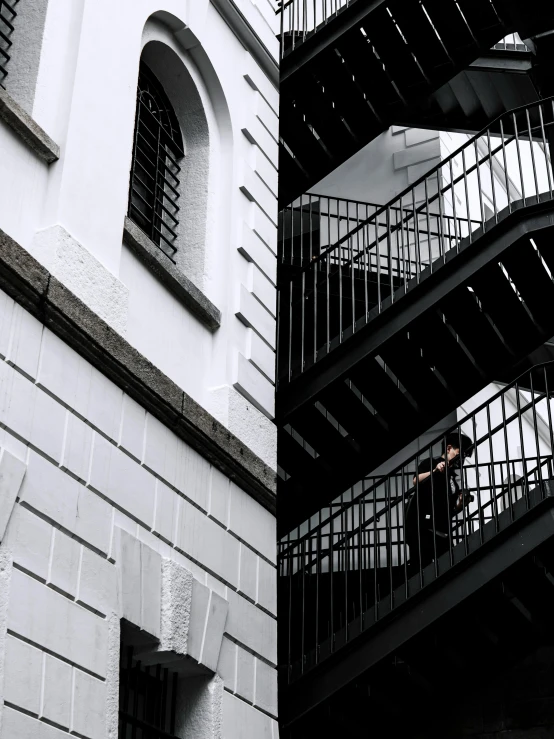 a man walking down a flight of stairs next to a building