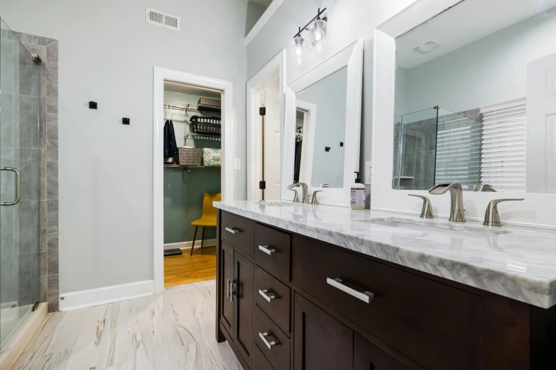 a large, bright bathroom with double sinks, a shower, and a toilet