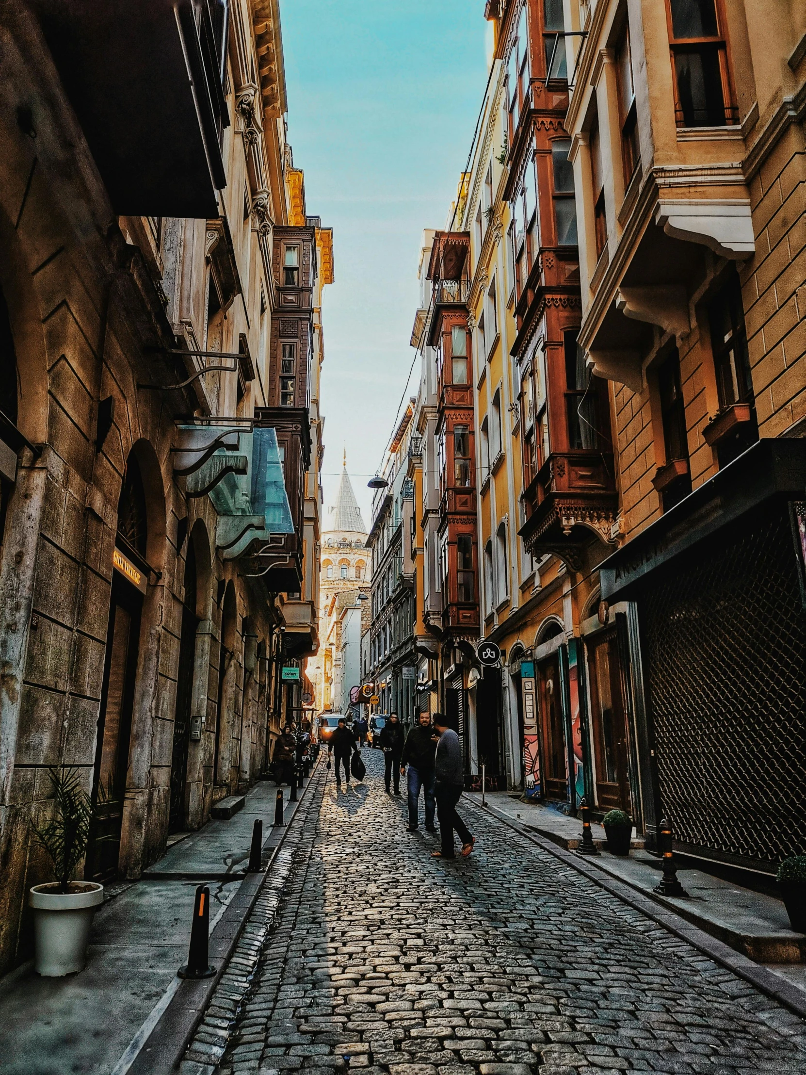 several people are walking down the cobblestone streets