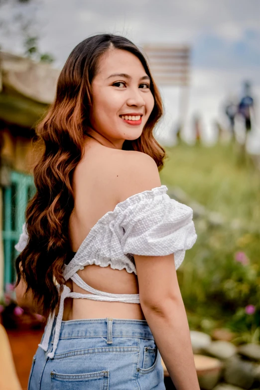 a woman in blue jean shorts smiling and looking away from the camera