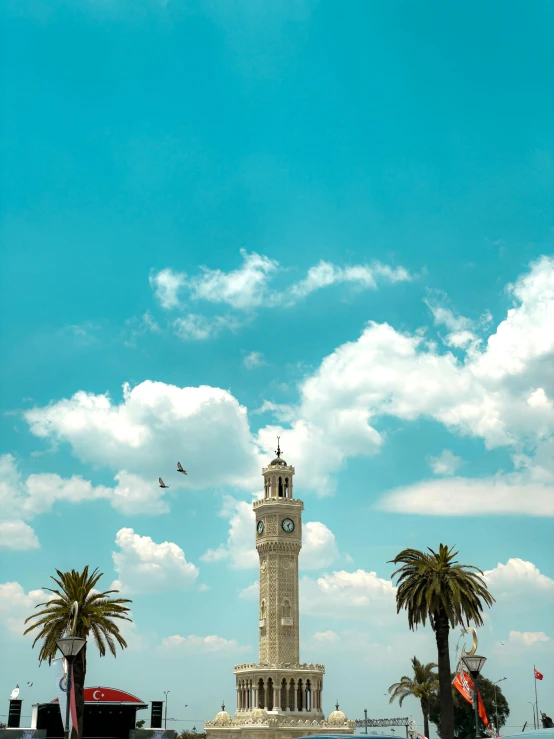 a clock tower in a tropical setting with palm trees