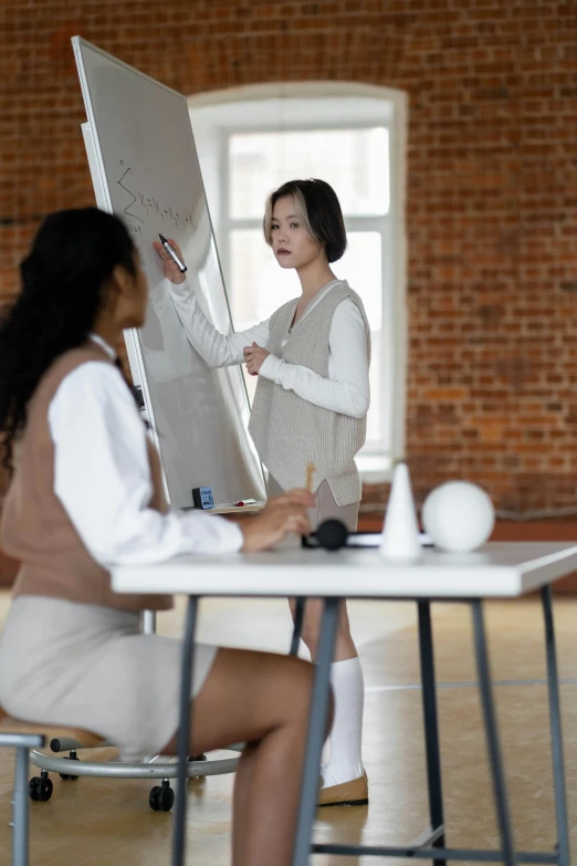 two women and a woman in dress are standing by a easel