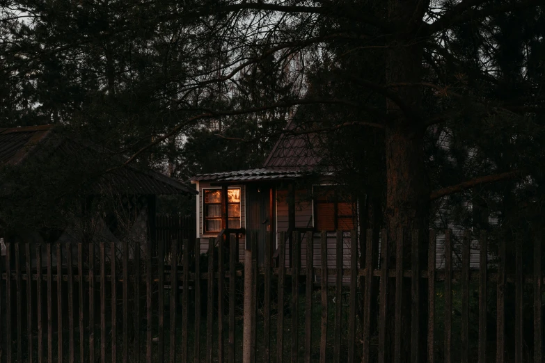 a house is seen through the trees at night