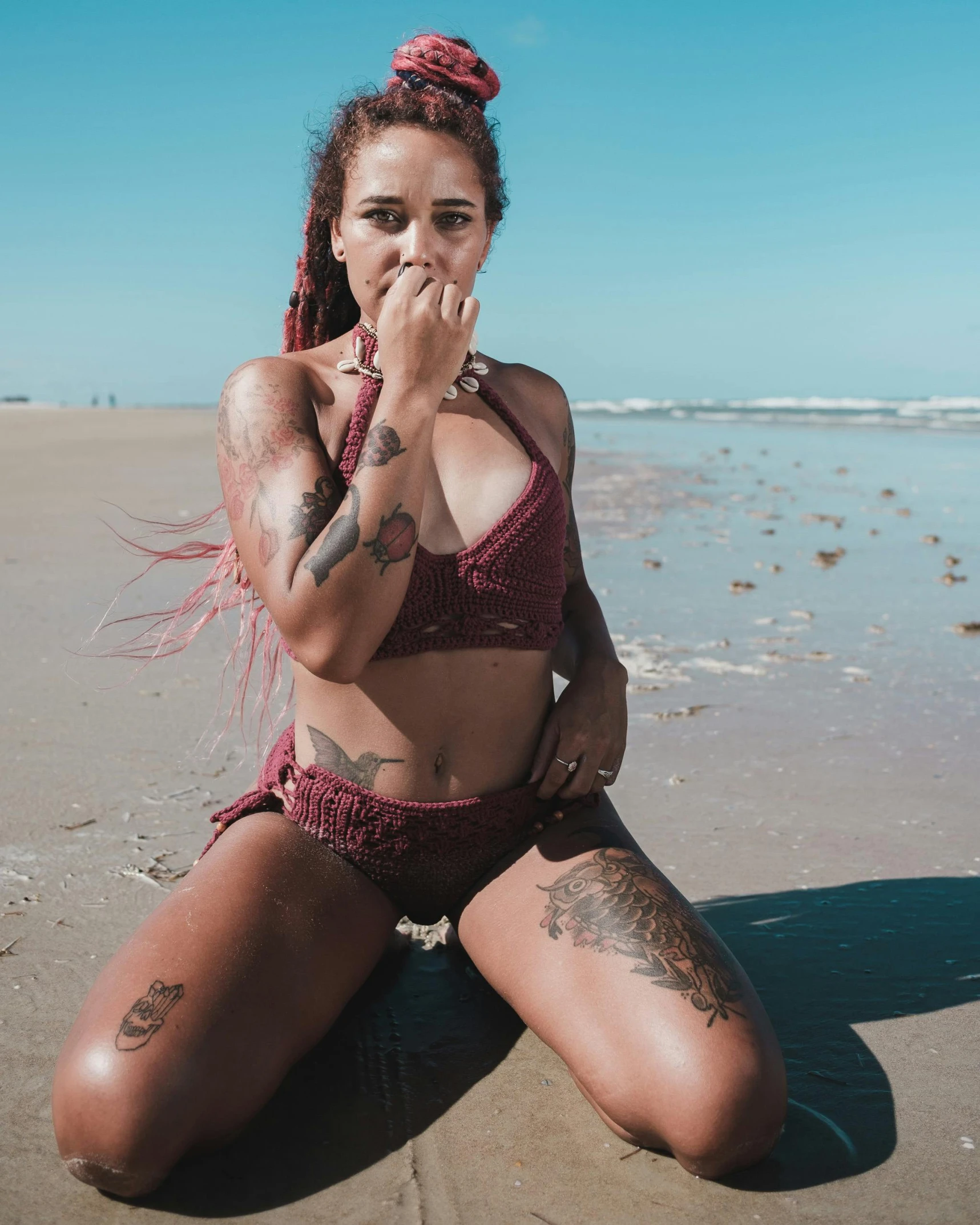 a woman sitting on the beach in front of water