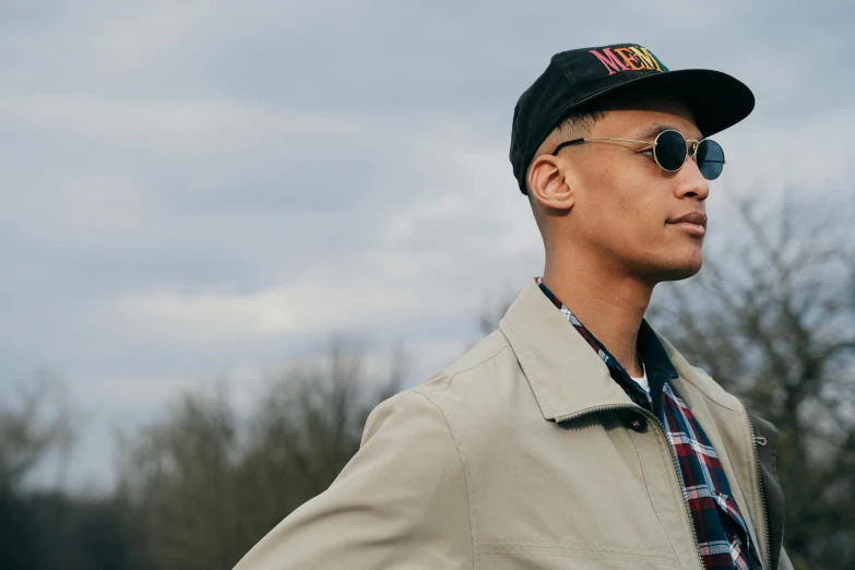 a young man wearing a black hat with sunglasses