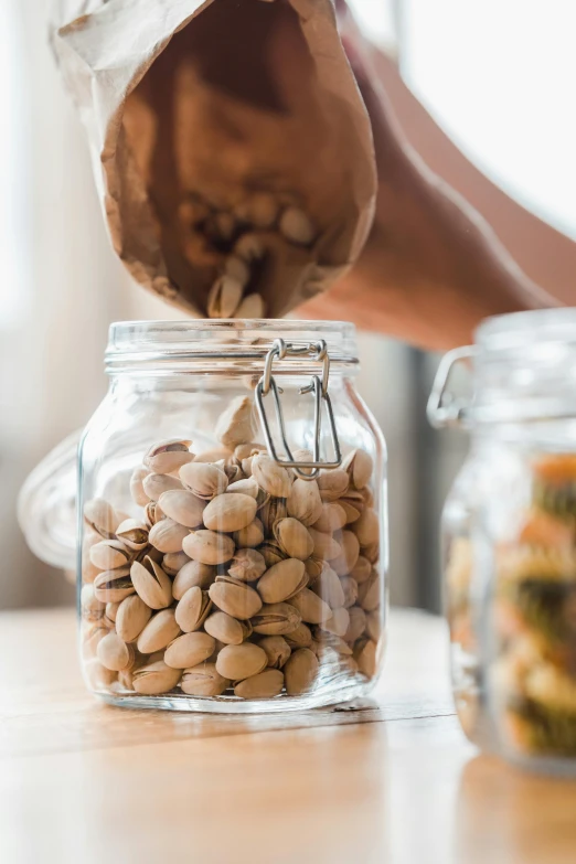 a hand pouring soing into a small jar