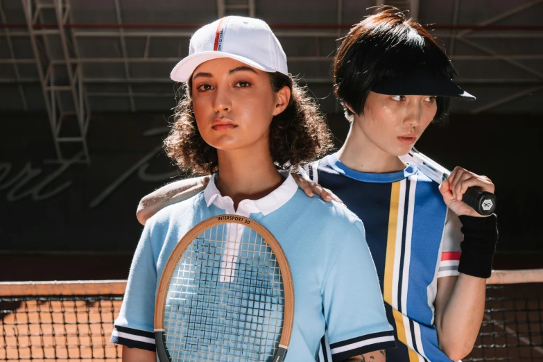 two tennis players dressed in old school uniforms with rackets