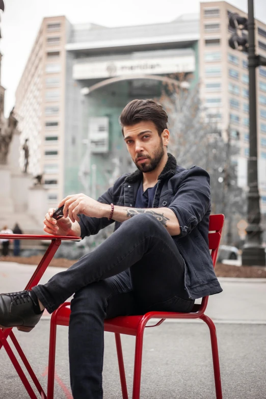 a man that is sitting in a red chair