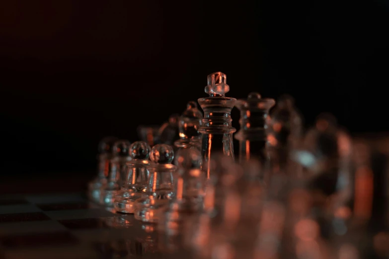 several clear glass pieces on a black and white chess board