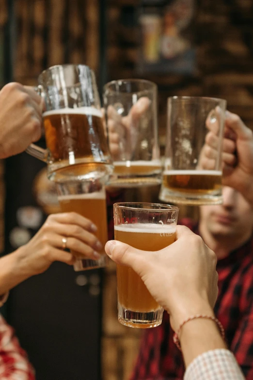 people are toasting with glasses of beer