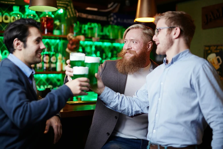 men are standing together with glasses of beer