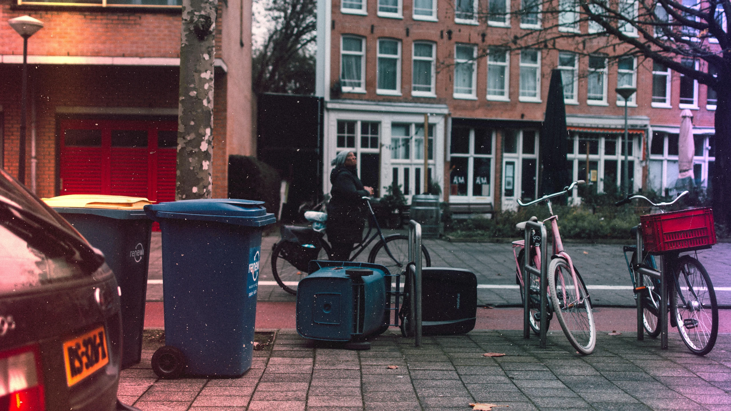 a group of luggage and a bicycle are  to a post