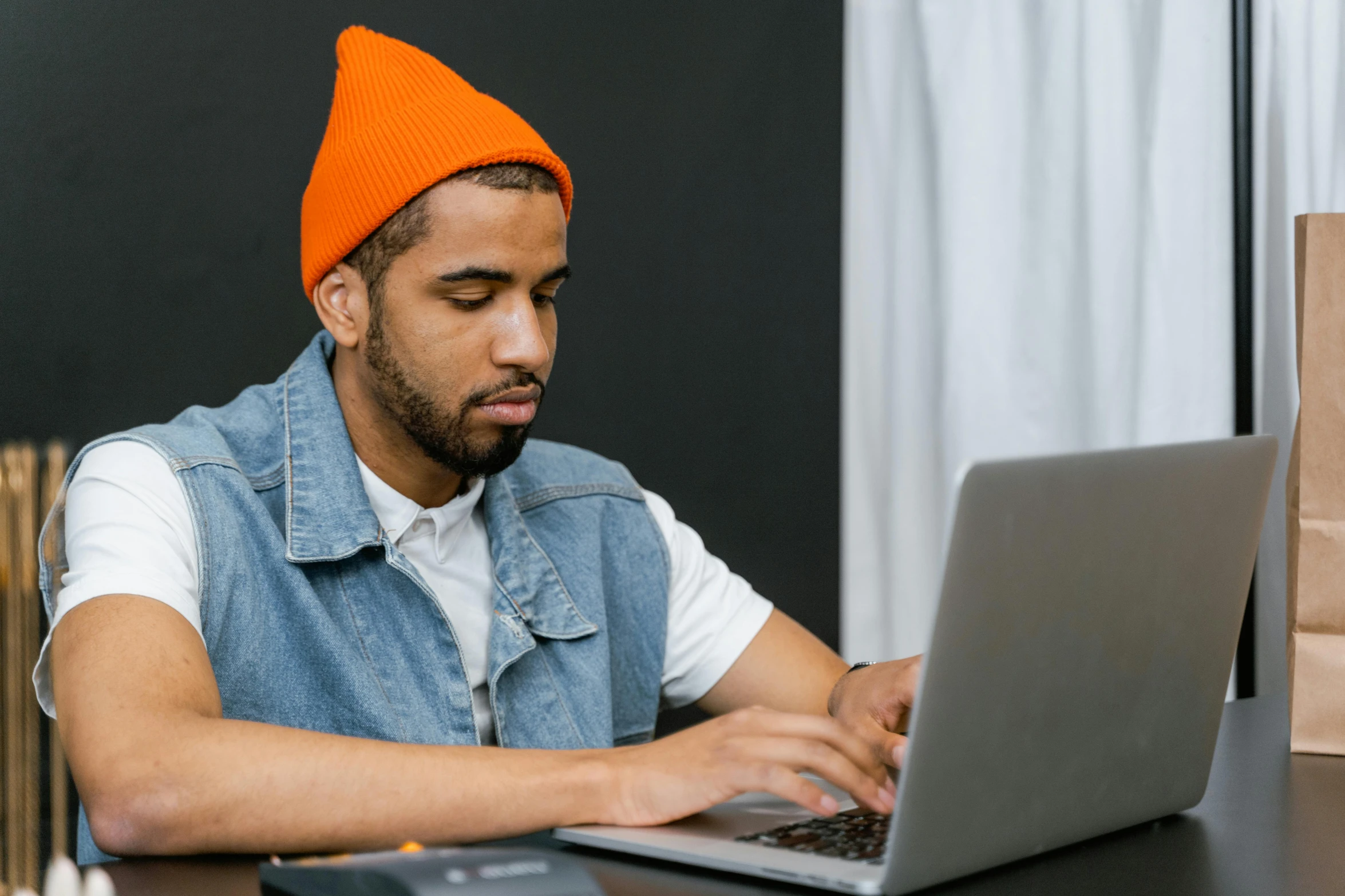 man sitting at table in front of laptop