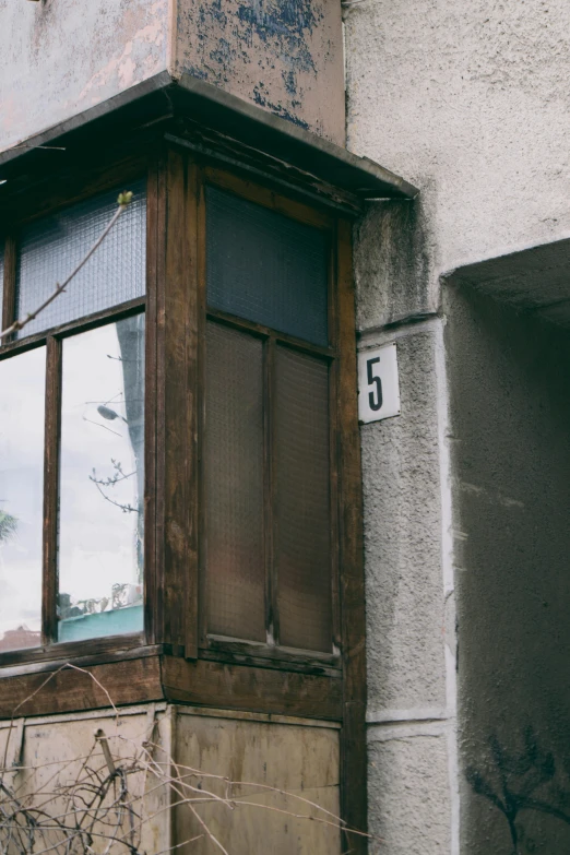 a window with shutters sits next to a building