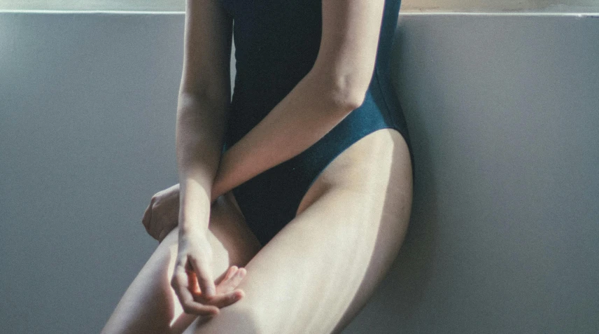 a woman sitting on top of a chair next to a window