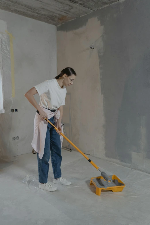 a man holding a mop and cleaning the floor