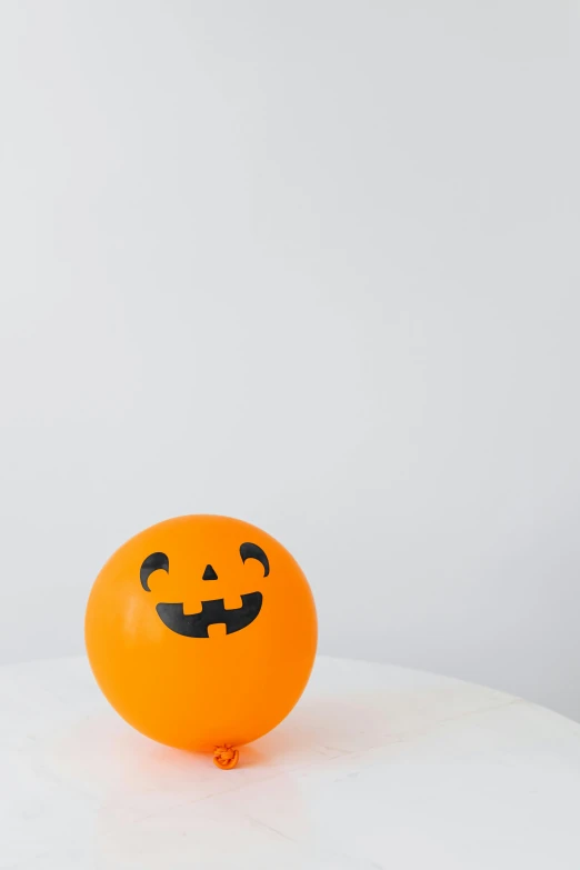 an orange balloon that has a smiley face on it