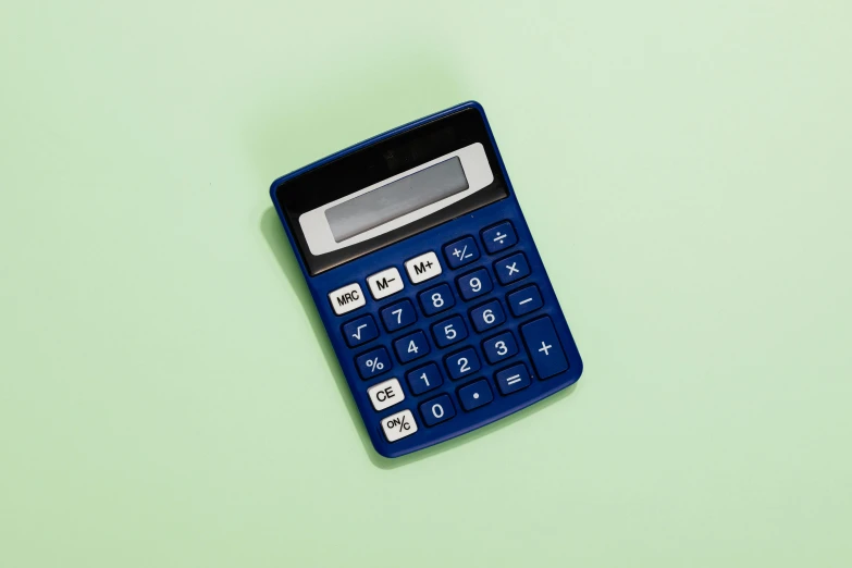 a blue calculator that is sitting on a green surface