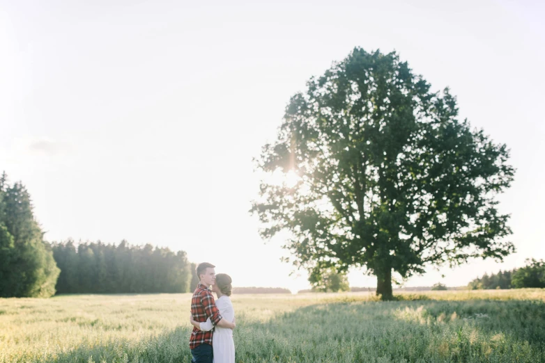 a man and woman standing in a field near each other