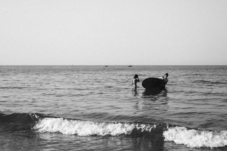 two people in the ocean near a boat