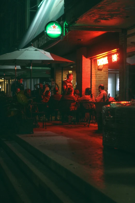 group of people seated at tables under an outdoor restaurant