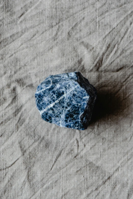 a rock that is sitting on a brown sheet