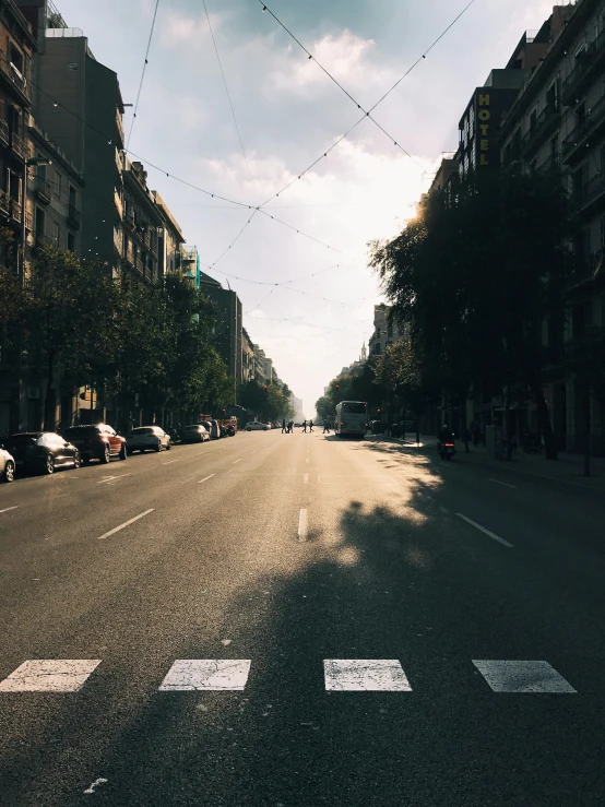 a deserted street is lined with parked cars