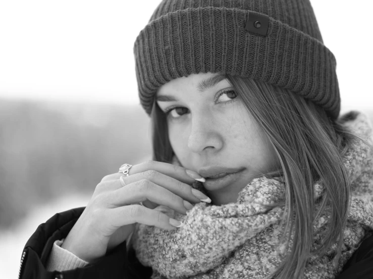 black and white picture of a girl holding soing up her mouth