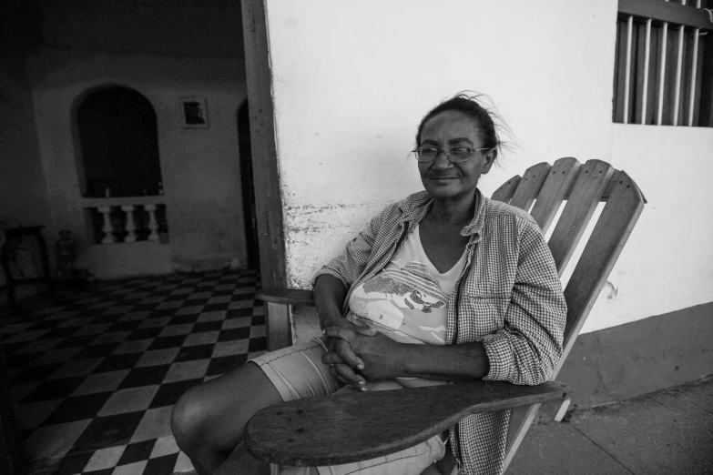 a woman sitting in a chair and holding a  dog