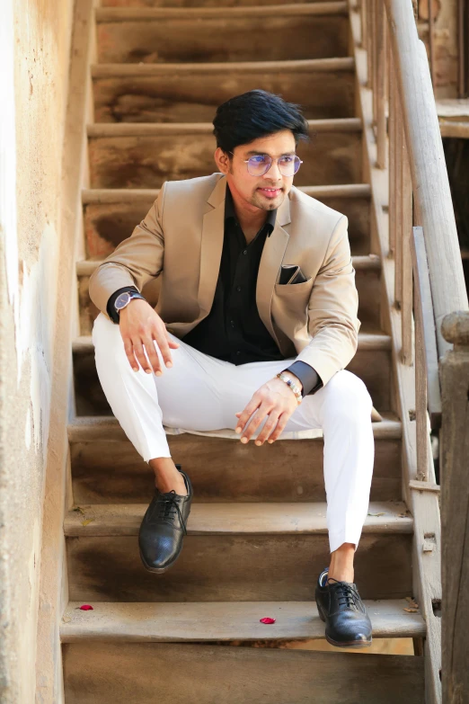 man sitting on top of wooden step in front of an open staircase