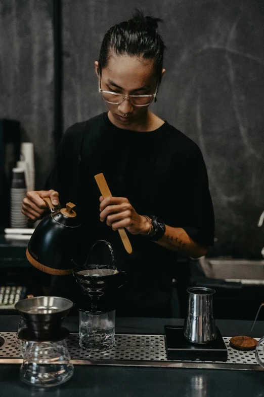 a person wearing glasses and holding soing in their hand