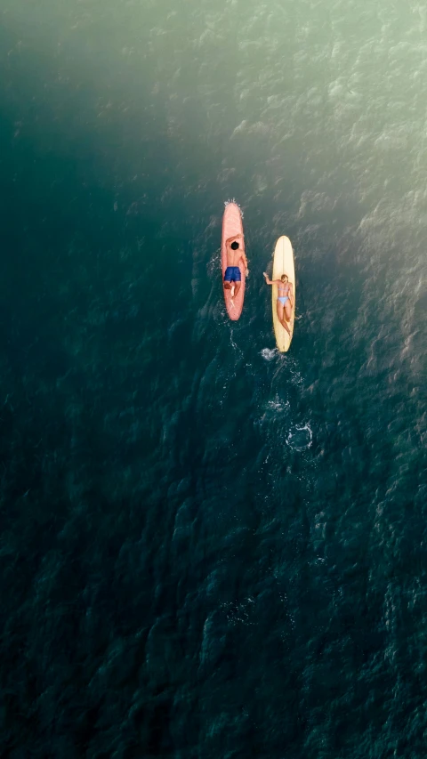 two people in kayaks swimming in the ocean