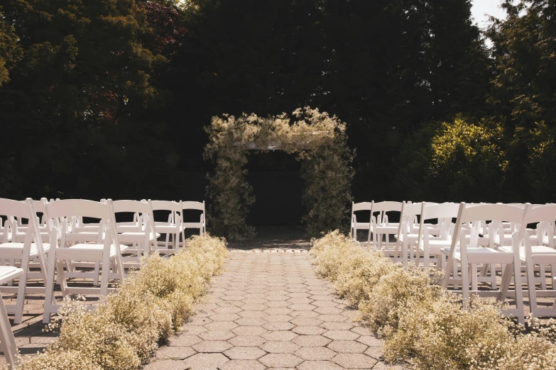 a set of white chairs sits next to a path