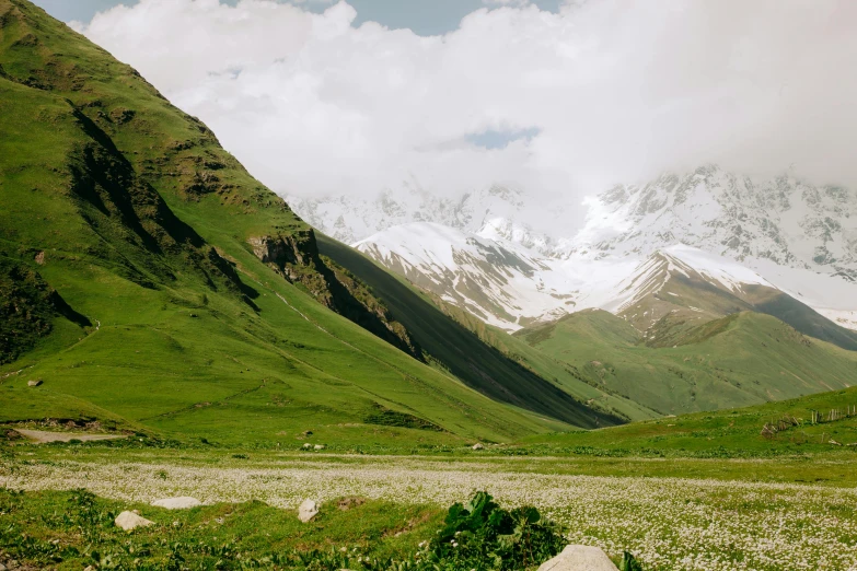 large mountains with snow on the tops, near a dirt road