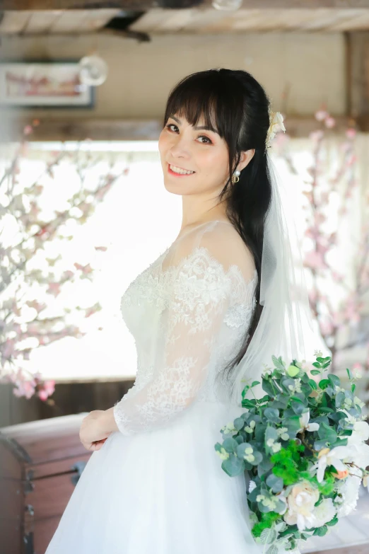 a young asian bride with a bridal gown and bouquet