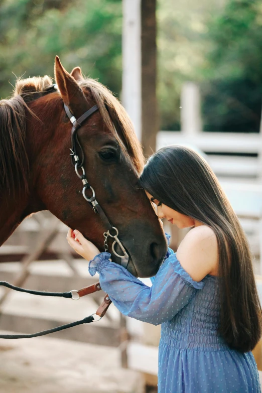 the woman is petting the horse's head as she stands close to it