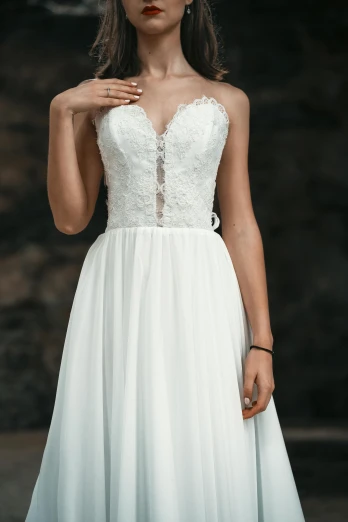 a woman standing wearing a white wedding dress