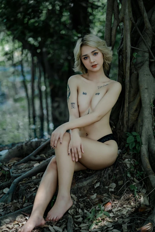 a  woman posing by a tree in the woods