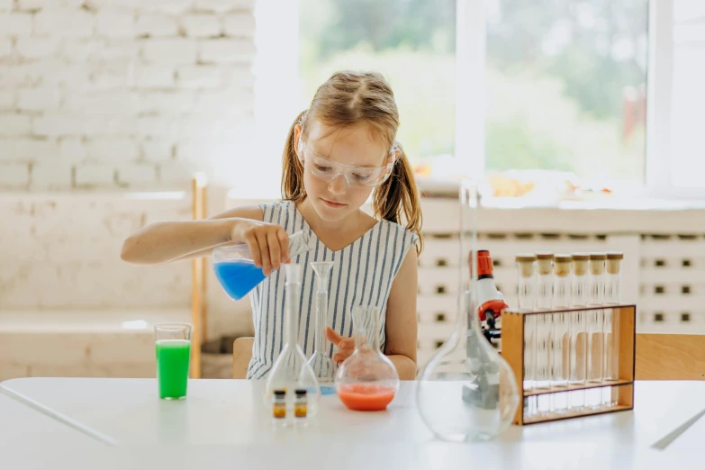 the little girl is painting in her classroom