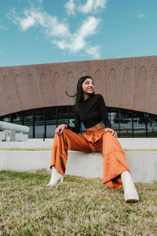 a woman sitting on a wall with her legs crossed