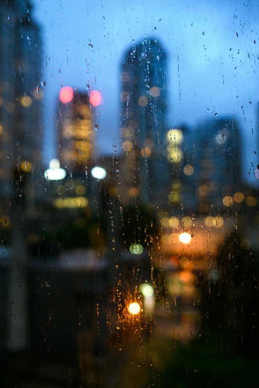 a view of a city from inside a rain covered window