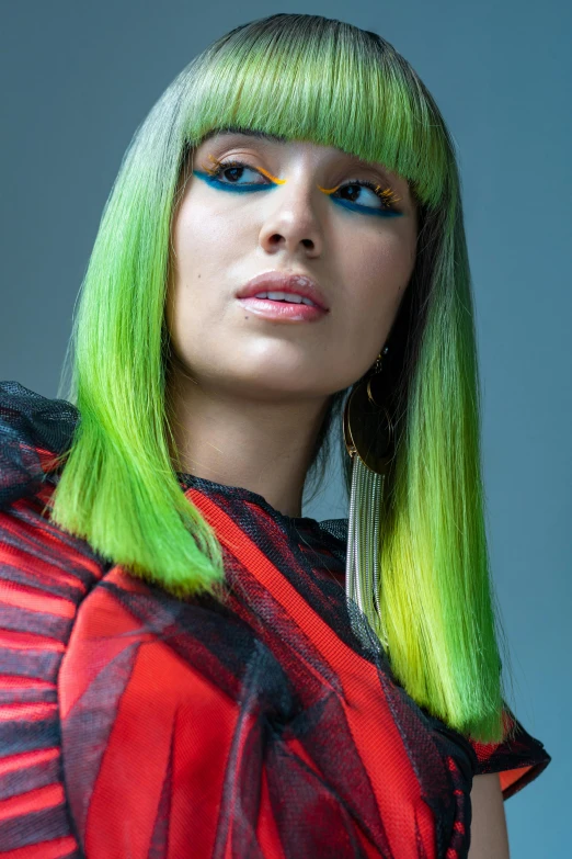 a woman with bright green hair and blue eyes