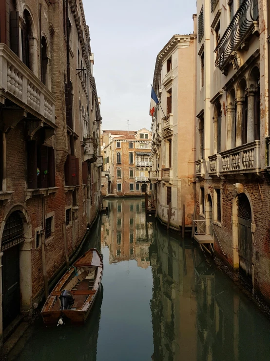 some buildings and a boat in a very narrow river