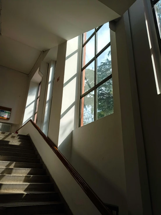 an empty stairway with windows overlooking a lake