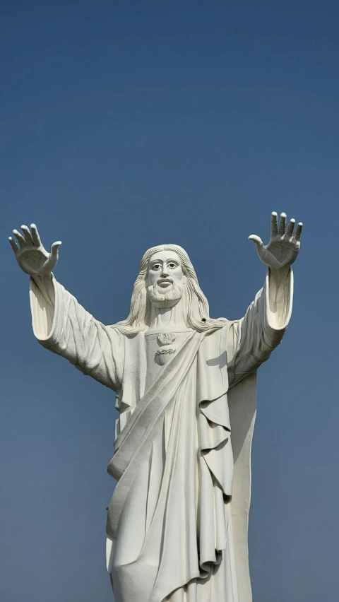 a statue of jesus is reaching his arms up