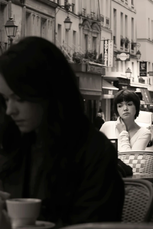 two women in a cafe drinking coffee together