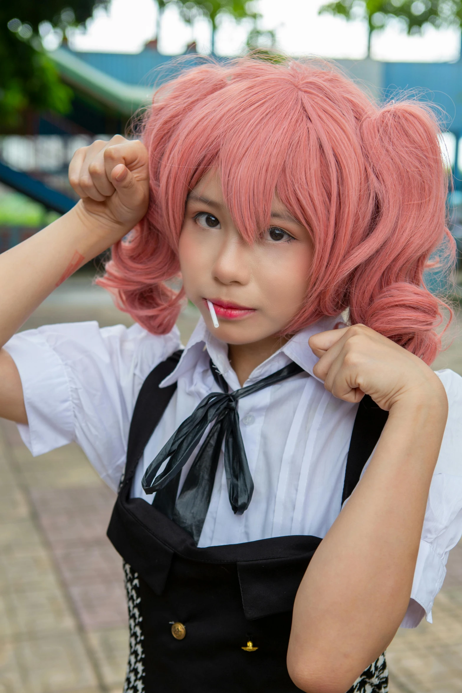 a woman with long pink hair putting on a bow tie