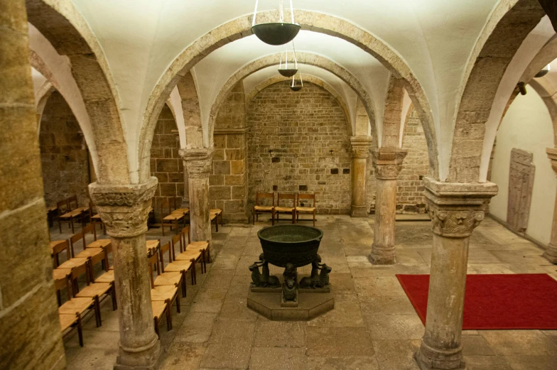 a stone building with columns and a round black fire place