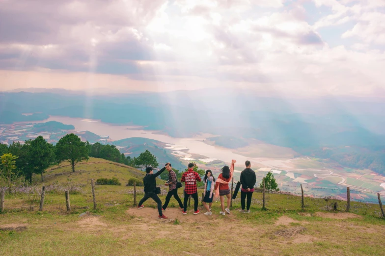 a group of people are standing on a grassy hillside